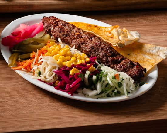 Adana kebab plate with salads and flatbread